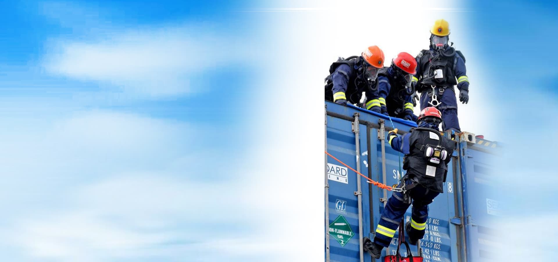 Emergency responders in protective suits and helmets on a shipping container